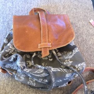 Grey floral backpack with leather adjustable straps.